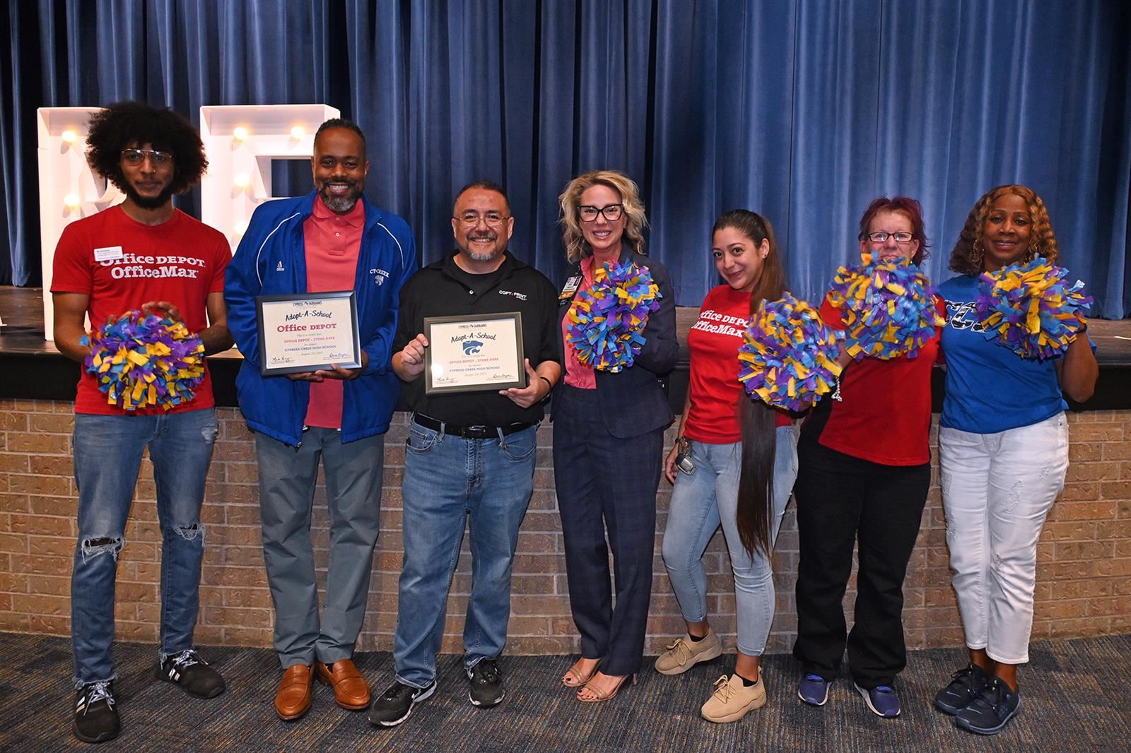 Martin Drayton, Cy Creek principal, and Luis Alvarado, store manager of Office Depot, hold plaques.